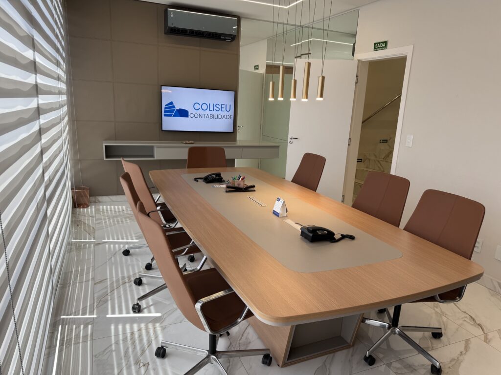 Foto da reunião master olhando para a TV e de costas para o elevador